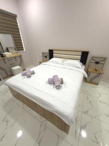 a bedroom with a bed with two towels on it at NiNi HOSTEL in Tashkent +4 photos