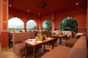een restaurant met rode muren, tafels en stoelen bij Stamps By Eight Continents, Pushkar in Pushkar +33 foto's