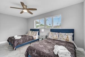 Un dormitorio con dos camas y un ventilador de techo. en Private Pool Vacation Home Near Beach Newly Renovated, en Deerfield Beach
