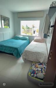 een slaapkamer met twee bedden en een raam bij Casa Oliveira in Cayru