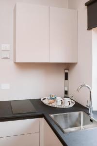a kitchen with white cabinets and a sink at Evi Suite in Santa Margherita Ligure