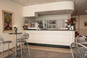 a bar in a restaurant with chairs and a counter at Euro Hotel in Cascina