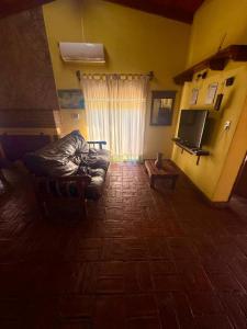 un soggiorno con un divano e una televisione di Alma de Lago a Villa Rumipal