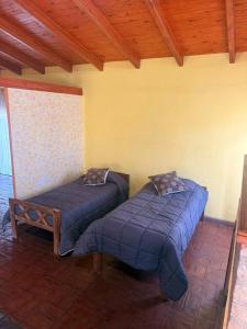 una camera da letto con due letti e soffitto in legno di Alma de Lago a Villa Rumipal