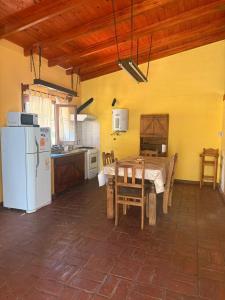 una cucina con un tavolo e un frigorifero bianco di Alma de Lago a Villa Rumipal