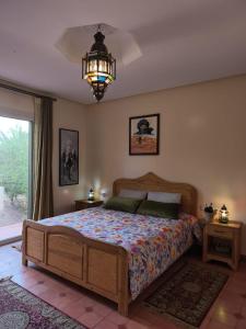 a bedroom with a large bed and a chandelier at Villa Essalah & Spa Marrakech in Marrakech