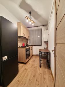 eine Küche mit einem Tisch und einem schwarzen Kühlschrank in der Unterkunft Apartament ultracentral Ștefan cel mare in Craiova
