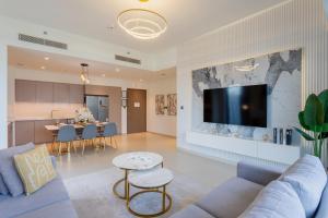 uma sala de estar com um sofá e uma TV na parede em Vacationer I Luxury 2 Bedroom I Burj Khalifa View I Downtown I Free Gym, Pool, Parking & Wi-Fi no Dubai