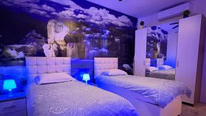 a bedroom with two beds in a room with purple lighting at Azure Apartment in Senglea