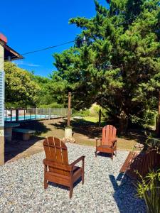 due sedie di legno sedute accanto a un albero di Alma de Lago a Villa Rumipal Altre 6 foto