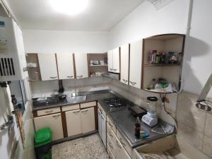 a small kitchen with white cabinets and a stove at Kumho in Medellín +23 photos