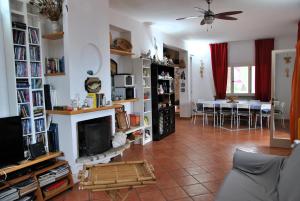 Una sala de estar con chimenea y un comedor. en Villa Giulia con piscina vista mare, en Sperlonga