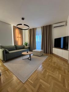 Una sala de estar con un sofá verde y una mesa. en Apartman La Campanella 2, en Vrnjačka Banja 35 fotos más