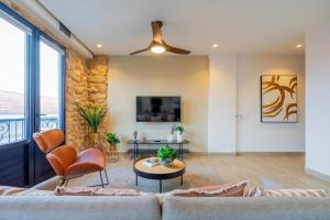 a living room with a couch and chairs and a tv at La Cuadra - Casco Viejo in Panama City