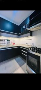 a kitchen with blue cabinets and a stove top oven at Edifício Cristo Rei in Marília +3 photos