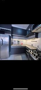a kitchen with blue cabinets and a stainless steel refrigerator at Edifício Cristo Rei in Marília