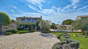 a house with a garden and a stone driveway at Rustic Villa Simone with outdoor pool in Porec in Krmenjak