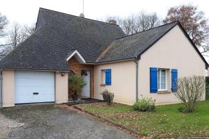 une maison blanche avec un toit noir et un garage dans l'établissement L'écrin sous les chênes - Wifi - Jardin, à Olivet