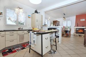 une cuisine avec des armoires blanches et un comptoir dans l'établissement L'écrin sous les chênes - Wifi - Jardin, à Olivet