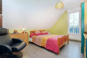 une chambre avec un lit et une chaise dans l'établissement L'écrin sous les chênes - Wifi - Jardin, à Olivet 15 autres photos