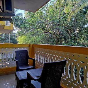 2 Stühle und ein Tisch auf dem Balkon in der Unterkunft Casa de Palmora 103 in Canacona