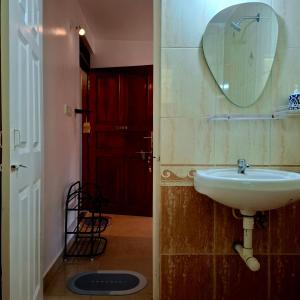 ein Badezimmer mit Waschbecken und Spiegel an der Wand in der Unterkunft Casa de Palmora 103 in Canacona