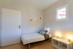 Un dormitorio pequeño con una cama y una ventana. en Chambre - Dorine, en Aroue