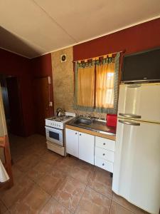 una cucina con un frigorifero bianco e un lavello di Las Casitas De Moni a Villa del Dique