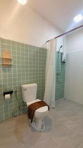 ein Bad mit einem WC und einer Dusche mit einem Duschvorhang in der Unterkunft Payim farm พายิ้มฟาร์ม in Ban Nam Khrai