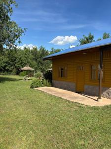 un piccolo edificio giallo con un tavolo e un ombrellone di Las Casitas De Moni a Villa del Dique
