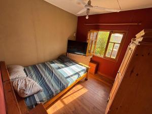 una piccola camera da letto con un letto e una finestra di Las Casitas De Moni a Villa del Dique