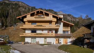 a large building with a balcony on a mountain at Sappada Family Apartments in Sappada