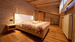 a bedroom with a bed with two towels on it at Sappada Family Apartments in Sappada