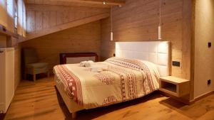 a bedroom with a bed in a wooden room at Sappada Family Apartments in Sappada +103 photos