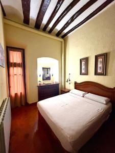 ein Schlafzimmer mit einem großen weißen Bett und einem Spiegel in der Unterkunft Apartamento medieval en el Camino De Santiago in Estella