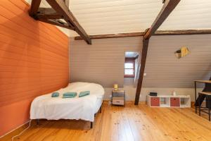 een slaapkamer met een bed in een kamer met houten vloeren bij Les dames de Salies in Salies-de-Béarn