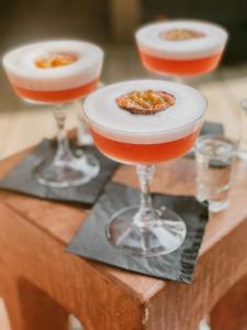 tre cocktail in bicchieri da vino su un tavolo di legno di Café Langelo a Langelo Altre 17 foto