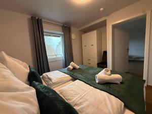 Kurpark Suites Bad Aibling في باد ايبلنغ: غرفة نوم بها سريرين مع مناشف عليهما