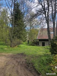 een persoon die in een veld naast een gebouw staat bij La Sauvagine in Les Fourgs