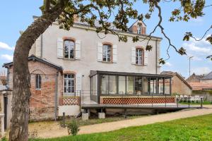 une grande maison blanche avec une grande véranda vitrée dans l'établissement Chambres & sde privatives dans maison partagée, à Clisson