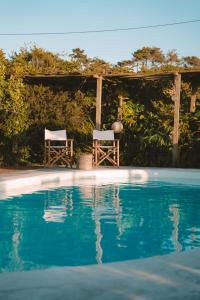 twee stoelen onder een prieel naast een zwembad bij João Jungle in Açafora