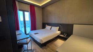 Postel nebo postele na pokoji v ubytování Kira Suites Hotel Milano + 6 fotografií