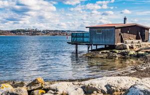 une petite maison sur la rive d'une masse d'eau dans l'établissement Lovely Home In Myggenäs With Sauna, à Krommeröd 11 autres photos