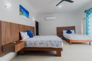 a bedroom with two beds and a table at Departamentos Blue Bacalar in Bacalar