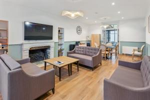 un salon avec deux canapés et une cheminée dans l'établissement Chambres & sde privatives dans maison partagée, à Clisson