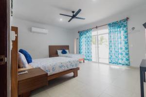 a bedroom with a bed and a large window at Departamentos Blue Bacalar in Bacalar