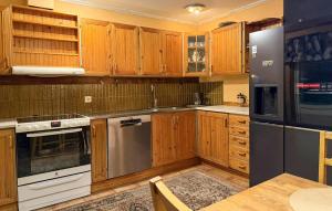 een keuken met houten kasten en roestvrijstalen apparatuur bij 4 Bedroom Pet Friendly Home In Karlstad in Våxnäs