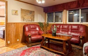 een woonkamer met een leren bank en een tafel bij 4 Bedroom Pet Friendly Home In Karlstad in Våxnäs