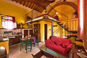 a living room with a red couch and a table at Fonte Del Castagno in Sinalunga