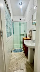 ein Badezimmer mit Glasdusche und Waschbecken in der Unterkunft Casa a 100mts da praia in Ilhabela